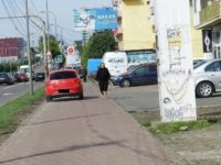 Trotuar transformat în bandă de circulaţie, cu maşini care circulă printre pietoni