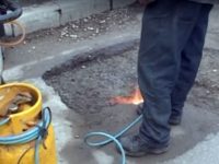 Drumarii asfaltează iarna gropile folosind butelii cu arzător