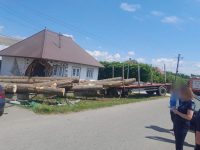 Două gospodării au fost avariate de buştenii răsturnaţi dintr-o remorcă